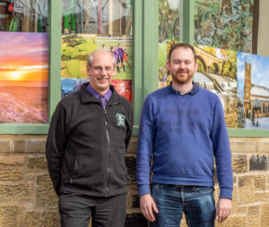 James and Neville standing beside the newly installed window photographs